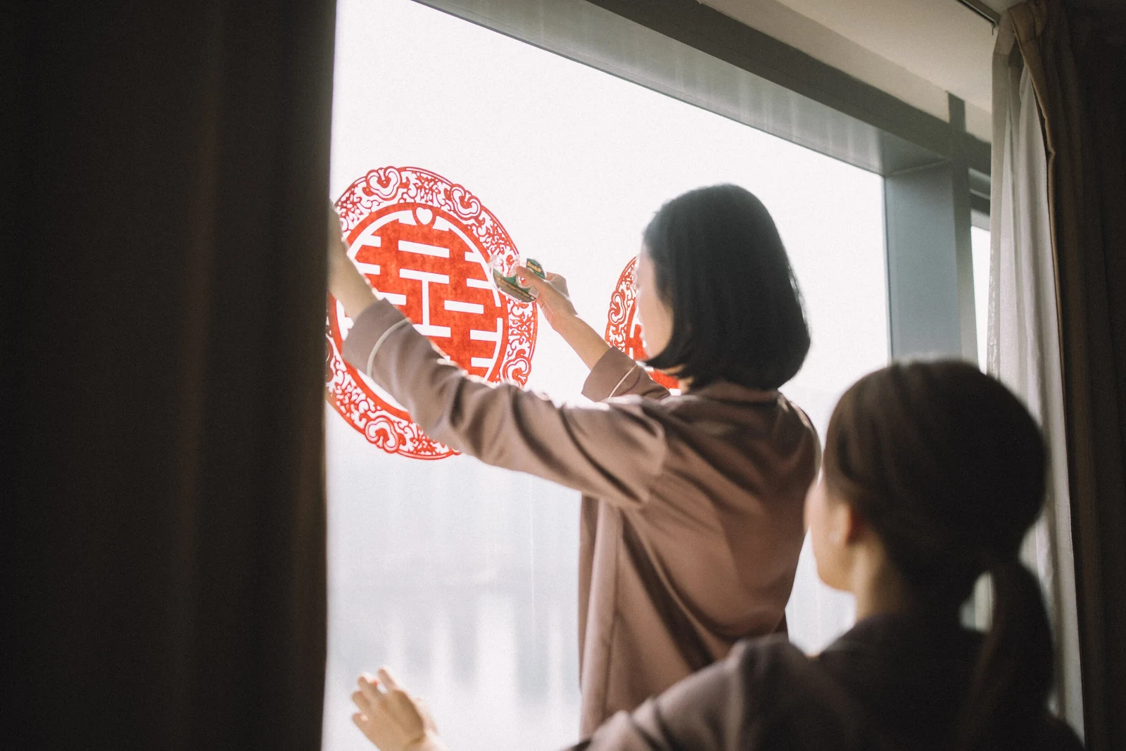 姊妹在窗上貼好紅色囍字,準備迎接新人