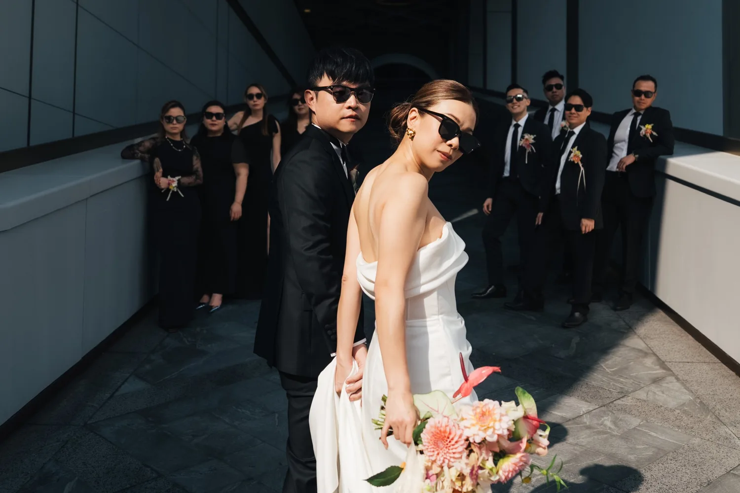 戴太陽眼鏡的 Phoebe 與 Jacky 在美利酒店斜坡通道前，與兄弟姊妹一起拍下婚禮合照