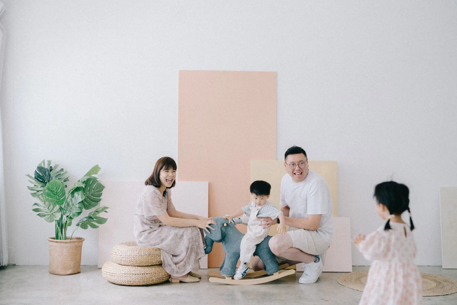 父母與孩子在室內坐在一起,孩子在前景走向家人