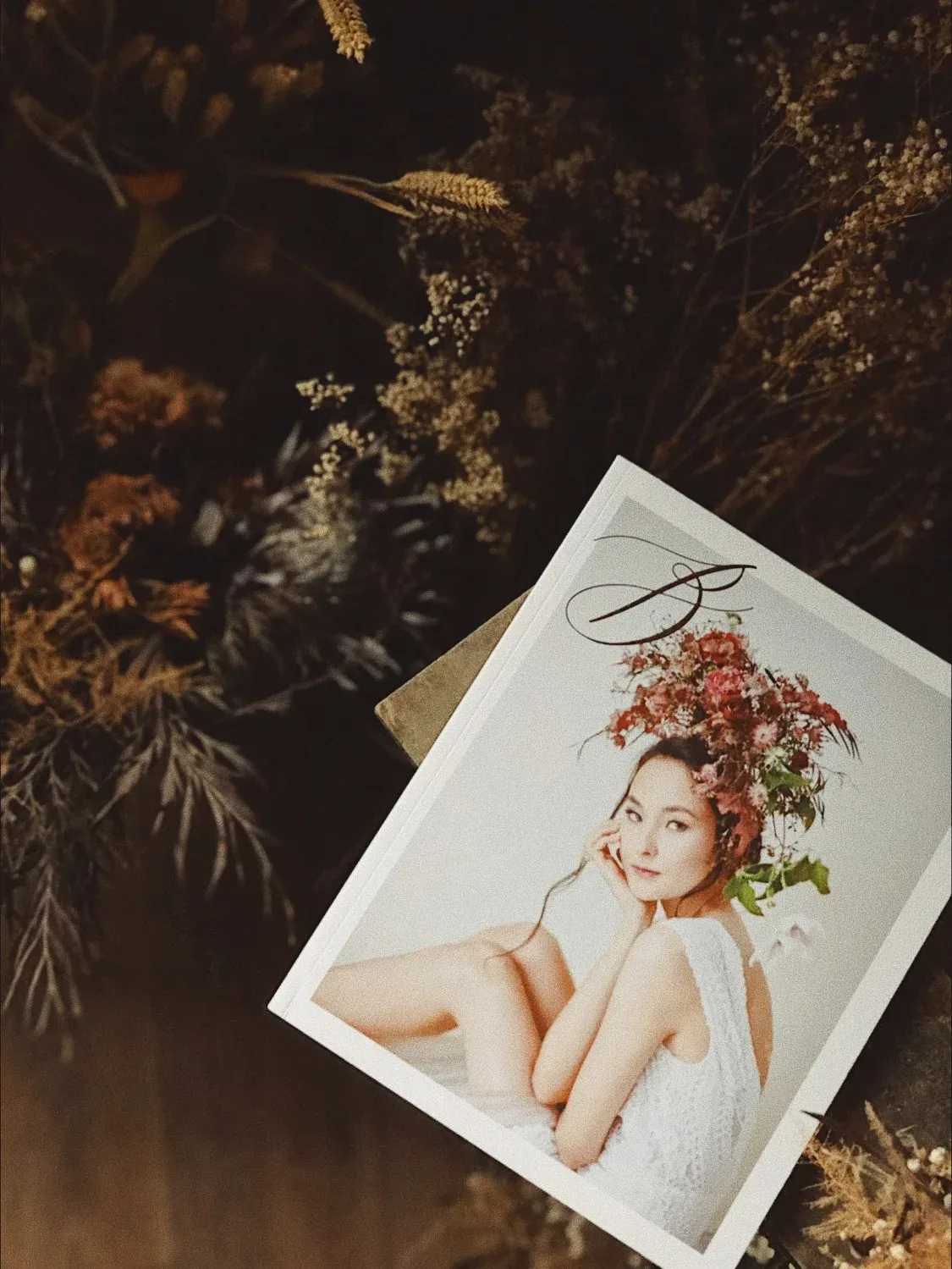放在植物旁的 BRIDES 人像印刷作品,封面是戴花飾的女子