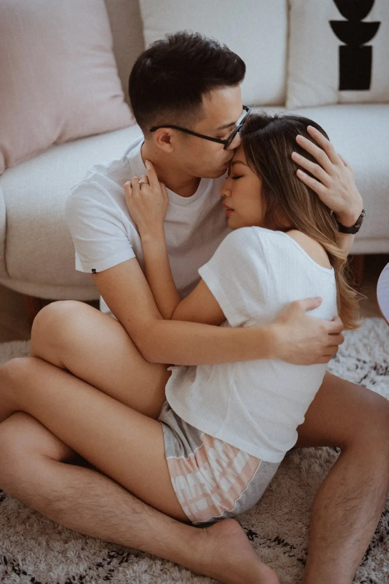 KYLIS 與 Justin 穿白色便服在沙發上相擁，男方親近女方額頭