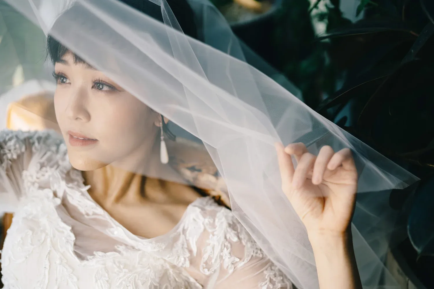 新娘抬手拉開頭紗,望向身旁的光線