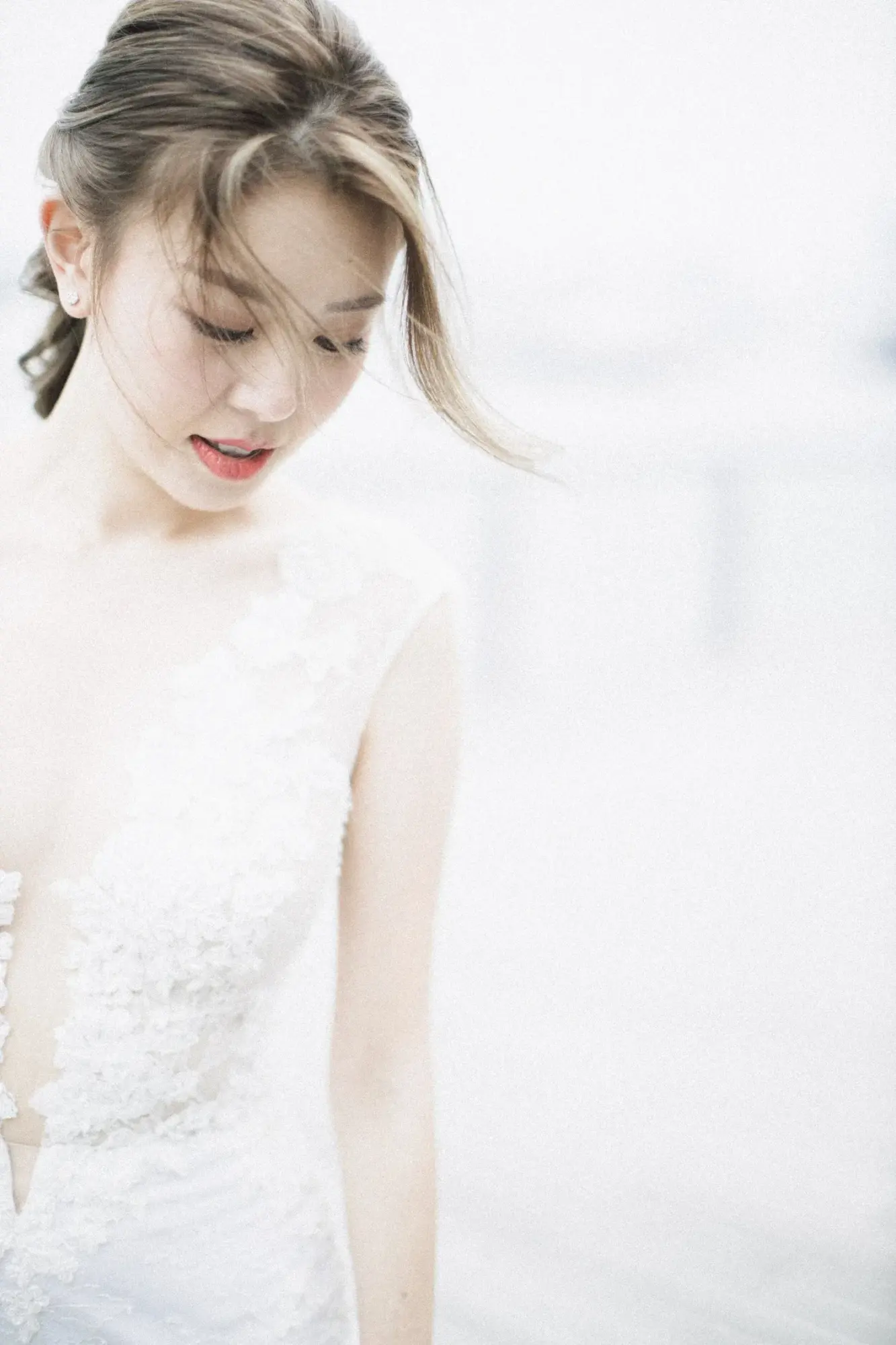 白色蕾絲婚紗新娘低頭,髮上插着小花