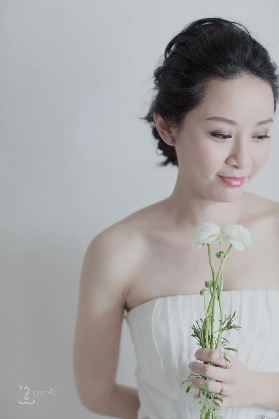 新娘手持一枝白色小花,低頭望向花朵